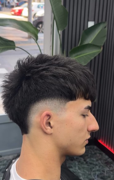 Crop texturizado con degradado bajo el neón de la barbería